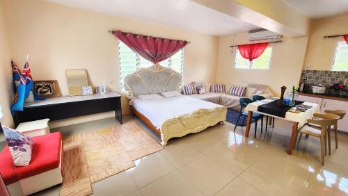 SigatokaPacific Paradise Villa的一间卧室配有一张床、一张沙发和一张桌子