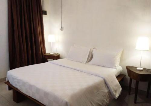 LonggaNaya Matahora Island Resort的一间卧室配有带白色床单和枕头的床。