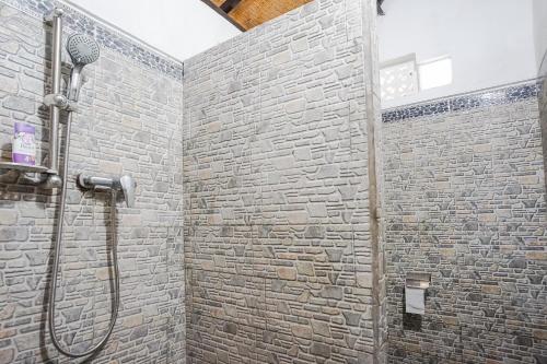 BalianMejan Home Stay的带淋浴的浴室(带石墙)