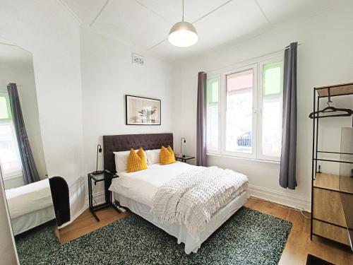 悉尼Stylish Queen Room 1Min Walk to Station with 60 Inch TV的一间卧室配有白色床和黄色枕头