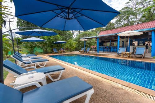 高兰穆克兰达生态度假酒店的游泳池旁设有躺椅和遮阳伞的游泳池