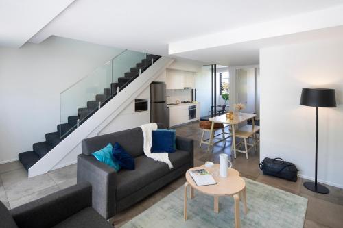 悉尼维鲁坎珀道酒店的带沙发和楼梯的客厅
