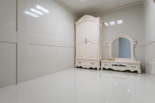 SongjuHotel Gaya的白色的浴室设有梳妆台和镜子