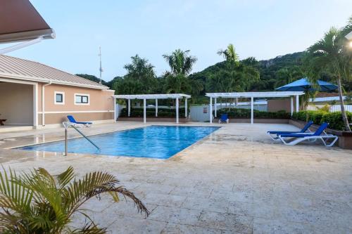 卢西Welcome to our Ocean View Villa!的一座带两把蓝色椅子的别墅内的游泳池