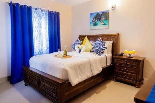 卢西Welcome to our Ocean View Villa!的一间卧室配有一张带蓝色窗帘的大床