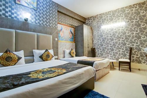 新德里Hotel HSP Suites At Delhi Airport的酒店客房,配有两张床和椅子