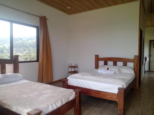 El Castillo de la FortunaVulkan Arenal Amazing View Lodge 4 WD的带窗户的客房内的两张床