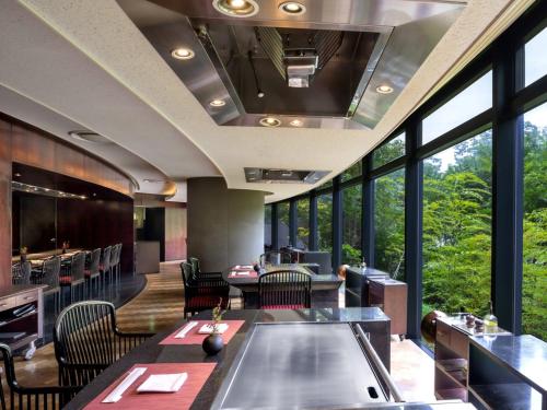 大阪Grand Prince Hotel Osaka Bay的餐厅设有桌椅和大窗户。