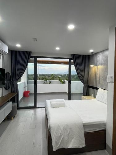 罗夷Lagi Beach Hotel的一间带大床的卧室和一个阳台