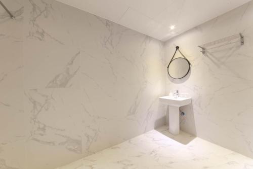 釜山HOUND HOTEL sasang branch的白色的浴室设有水槽和镜子