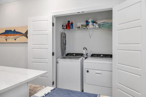 圣西蒙斯岛Baisden Cottage的厨房配有白色橱柜、洗衣机和烘干机