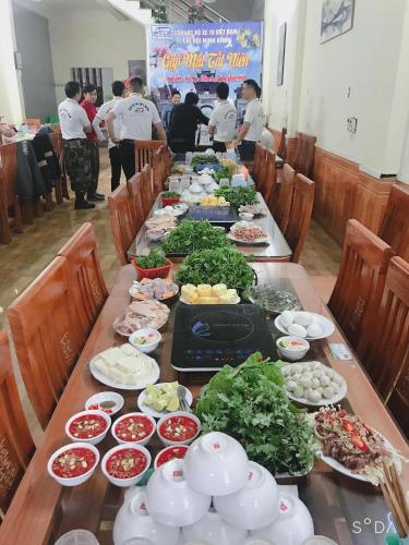 Tiên TânHotel Thi Hoa Bái Đính的一张长桌,上面放着许多盘子的食物