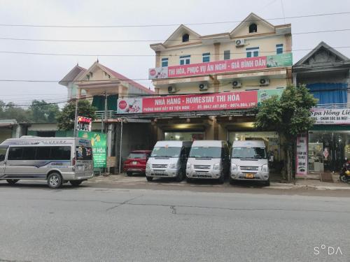 Tiên TânHotel Thi Hoa Bái Đính的停在大楼前的三辆白色货车
