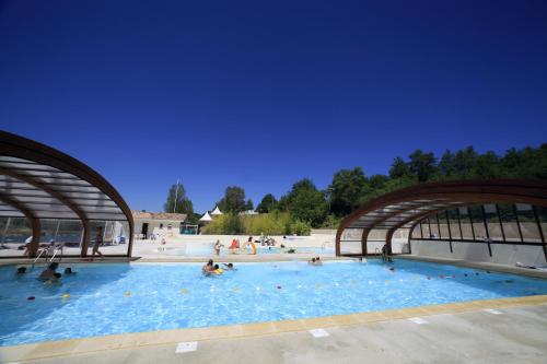Monclar-de-Quercy法兰西泰尔阿莫德拉克假日公园的一座大型游泳池,里面的人都沉浸在水中
