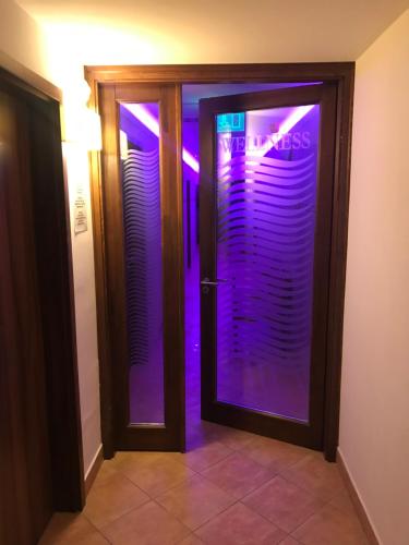 赛伦奇Meggyes Hotel的玻璃门,上面有紫色的灯