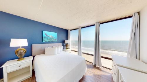 默特尔比奇Willow Bay Resort的一间卧室设有一张床和一个海景大窗户