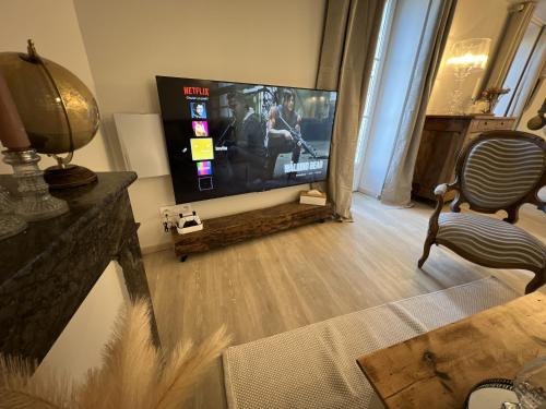 鲁埃格自由城Babolène Shabby Suite的客厅配有平面电视和椅子。