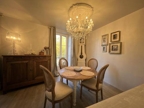 鲁埃格自由城Babolène Shabby Suite的一间带桌椅和吊灯的用餐室