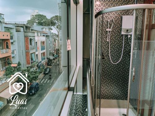 胡志明市Luas Cosy Home - The Cosy Chinatown Hideaway的阳台享有酒店的景致,配有淋浴。