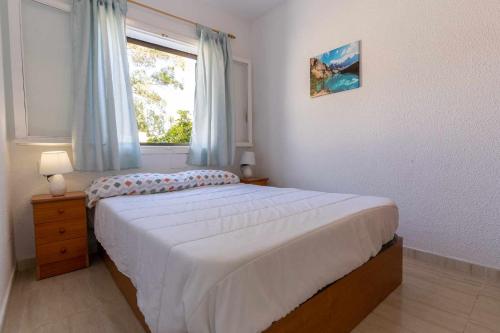 格兰阿利坎特rentafive Nuevo Barbacoa Terraza Playa的一间卧室设有一张大床和一个窗户。