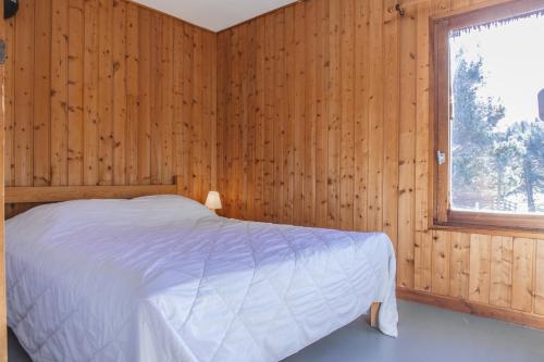 圣但尼Les Bouviers的卧室配有木墙内的一张床