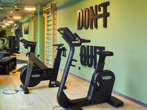巴登-巴登TRIBE Baden-Baden的一间健身房,里面设有跑步机和椭圆机