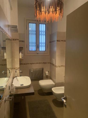 佛罗伦萨Cascine Park Florence Apartament的浴室设有2个卫生间、2个水槽和1个吊灯。