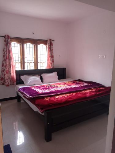 乌提Sai Trishuul home stay的一间卧室配有一张床铺,床上铺有红色毯子