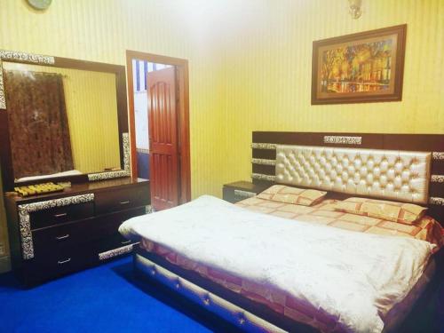 穆里Rashk e Qamar的一间卧室配有一张床和一面大镜子