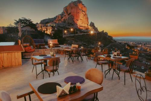 于尔居普Tale Cave İnn的一间设有桌椅的餐厅,享有山景