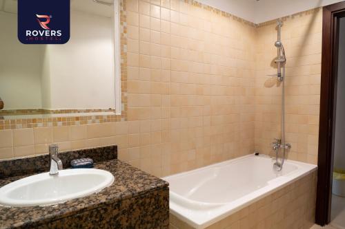 迪拜Rovers Hostel Dubai的浴室配有盥洗盆和浴缸。