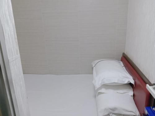 香港富都賓館 Fu Dou Guest House的小房间设有一张带两个枕头的床