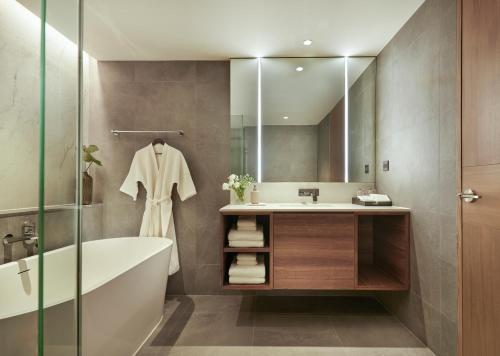 曼谷毕里斯顿苏安园景酒店 - SHA Plus的带浴缸、水槽和镜子的浴室