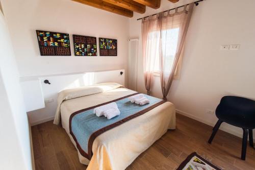 苏塞加纳Terre Boscaratto的卧室配有床、椅子和窗户。