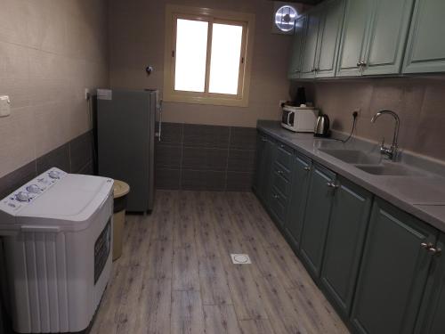 艾卜哈نيو العرين بارك أبها的一间带水槽和冰箱的小厨房