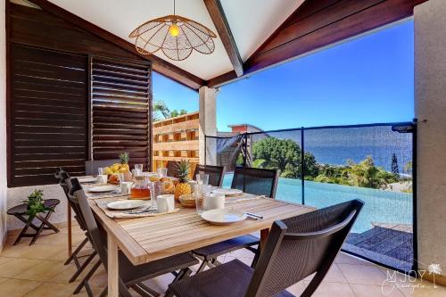 莱萨维龙La KazArmor et sa vue panoramique sur l'océan的美景庭院里的木桌和椅子