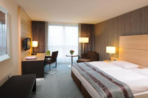 杜塞尔多夫玛丽蒂姆杜塞尔多夫酒店的酒店客房设有一张大床和一张书桌。