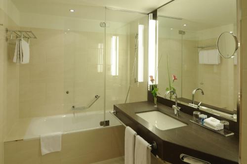 杜塞尔多夫玛丽蒂姆杜塞尔多夫酒店的带浴缸、水槽和镜子的浴室