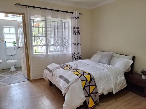 纳库鲁Ol-tome Country House - Nakuru的一间卧室设有一张床和一间浴室。