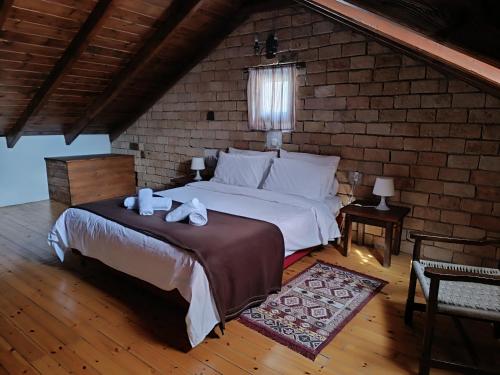 阿拉霍瓦PS Houses Arachova - PS Rental的一间卧室设有一张床和砖墙