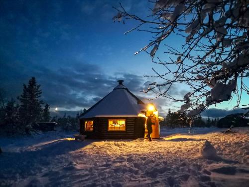 LifjellLifjellstua的一对夫妇站在雪地小木屋前