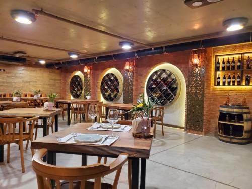 巴统Hotel Salvador的一间设有木桌和椅子的餐厅以及葡萄酒桶