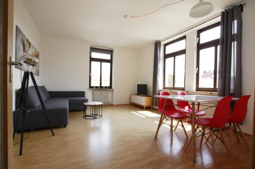 维尔茨堡Ferienwohnung 3 ANNA IFF的客厅配有桌子和红色椅子
