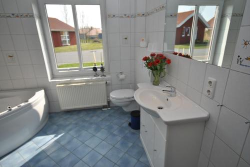 奥特尔恩多夫Ferienhaus Wattwurm的浴室配有盥洗盆、卫生间和浴缸。