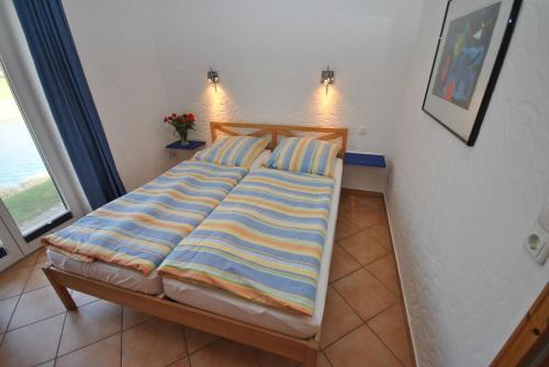 奥特尔恩多夫Ferienhaus Wattwurm的一张床上,床上有条纹毯子,放在房间里