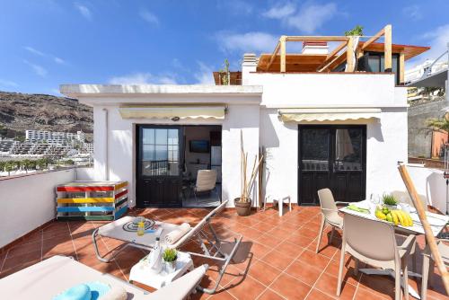莫甘Beach Apartment in Playa del Cura 323的房屋设有带椅子和桌子的庭院
