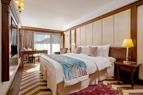 锡纳亚国际酒店 的酒店客房设有一张大床和一张书桌。