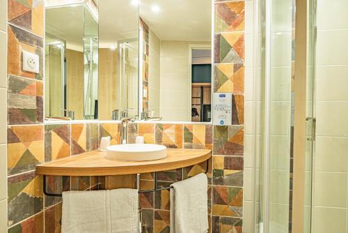布克贝莱尔基里亚德埃克斯米勒普兰加巴尼酒店的一间带水槽和镜子的浴室