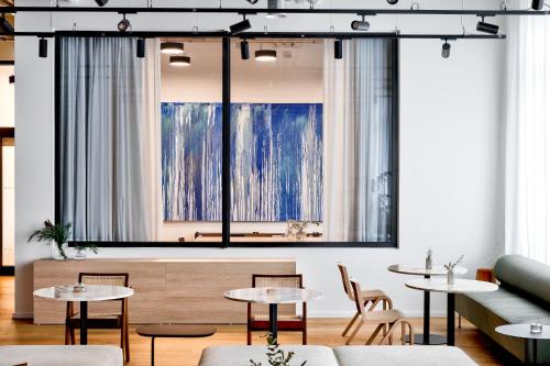 柏林Habyt-The Waterfront的客房设有桌椅和大窗户。