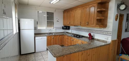 卡略萨登萨里亚Casa Rural Villa Micleta的厨房配有木制橱柜和白色冰箱。
